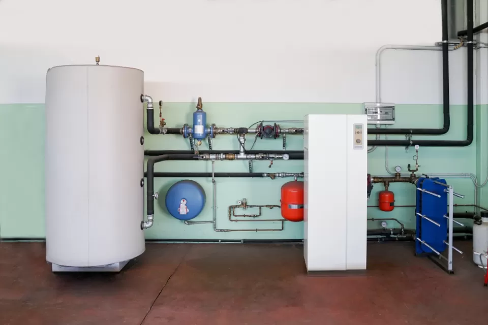 Geothermal heat pump installed on wall next to water boiler